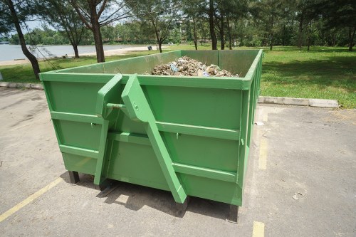 Man-and-van loading green waste from a riverside flat balcony